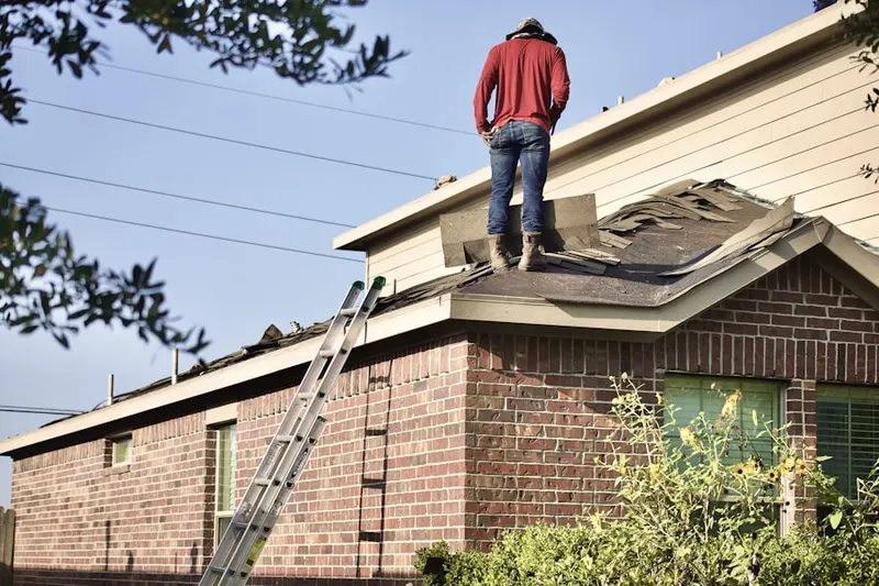 Professional roofer working on a residential roof in Carnesville